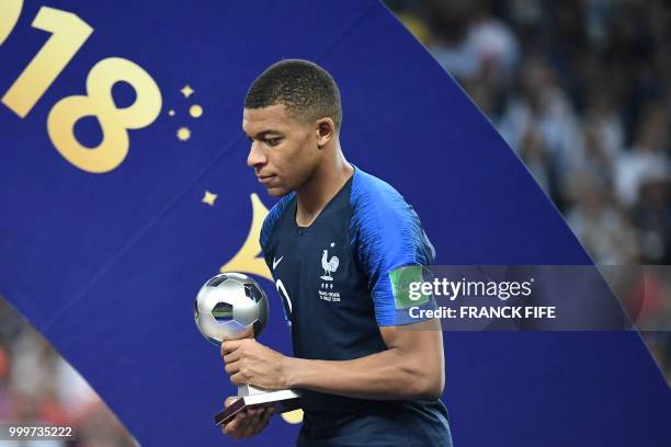 France's forward Kylian Mbappe poses with the FIFA Young Player award during the trophy ceremony at the end of the Russia 2018 World Cup final...