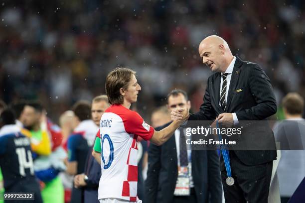 President Gianni Infantino award Luka Modric of Croatia his runners up medal following the 2018 FIFA World Cup Final between France and Croatia at...