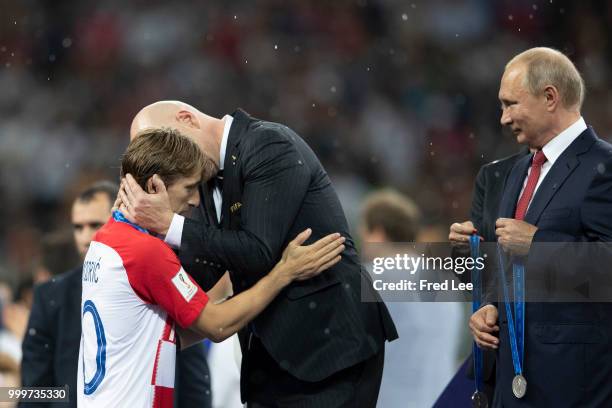 President Gianni Infantino award Luka Modric of Croatia his runners up medal following the 2018 FIFA World Cup Final between France and Croatia at...