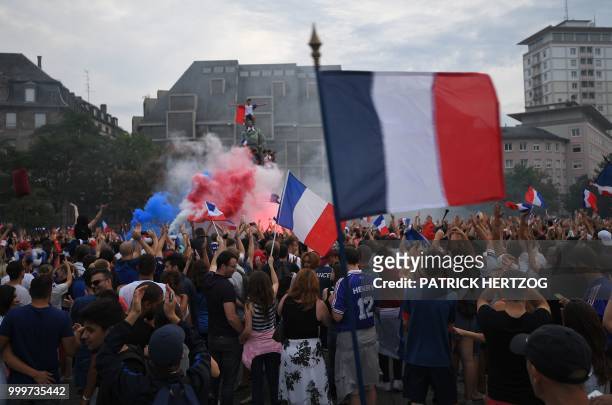 Peopler wave French national flags as they celebrate after France won the Russia 2018 World Cup final football match between France and Croatia, on...