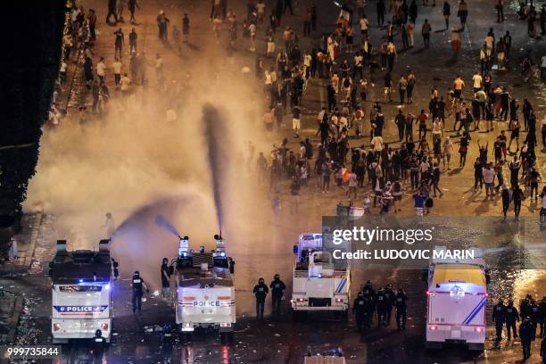 Police dispers people with water canons after celebrations following the Russia 2018 World Cup final football match between France and Croatia, on...