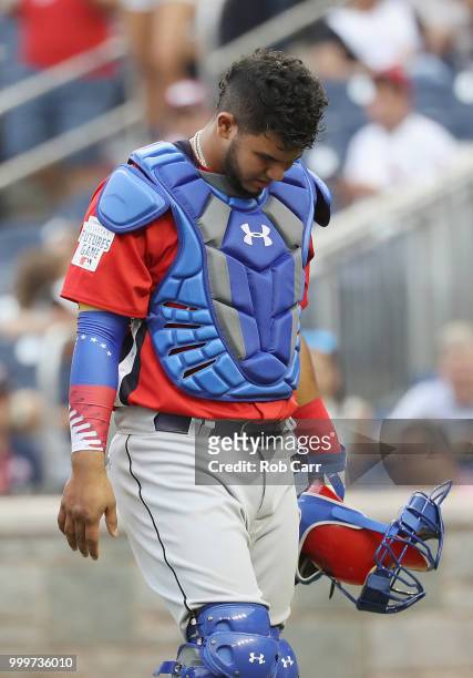 Keibert Ruiz of the Los Angeles Dodgers and the World Team leaves the game injured in the seventh inning against the U.S. Team during the SiriusXM...