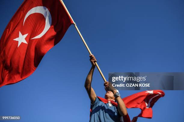 Man waves a Turkish flag, as people take part in a rally near the "15 July Martyrs Bridge", formerly called Bosphorus Bridge, in Istanbul, on July...