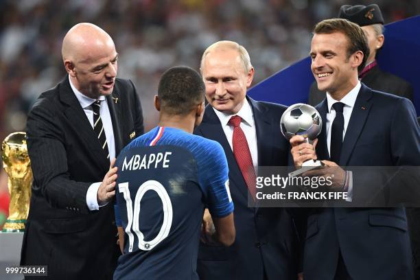 French President Emmanuel Macron , Russian President Vladimir Putin and FIFA president Gianni Infantino congratulate France's forward Kylian Mbappe...