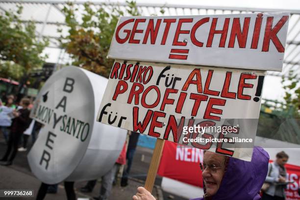 Protestors hold a large sign reading 'GM technology = Risk for all, Profit for the few' at a demonstration against the merger of Bayer and Monsanto...