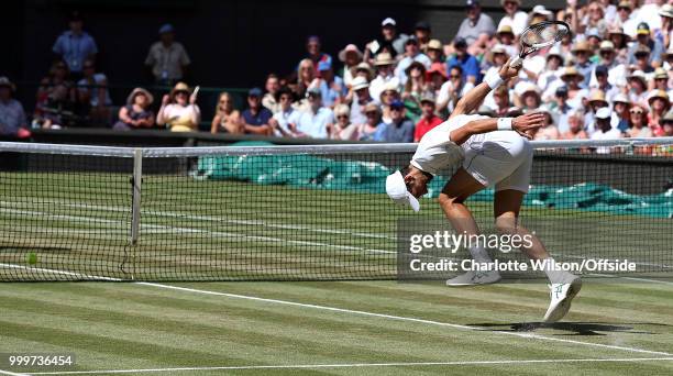 Mens Singles Final - Novak Djokovic v Kevin Anderson - Novak Djokovic folds forward as the ball hits the net at All England Lawn Tennis and Croquet...