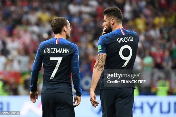 France's forward Olivier Giroud speaks to France's forward Antoine Griezmann during the Russia 2018 World Cup final football match between France and...