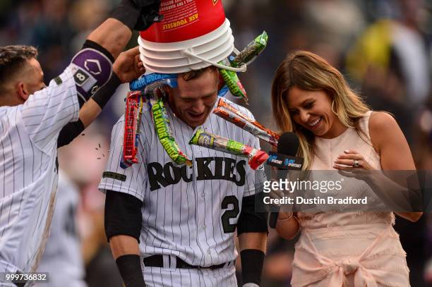 Trevor Story and Gerardo Parra of the Colorado Rockies celebrate a ninth-inning, walk-off home run by Story over the Seattle Mariners, as he gives a...