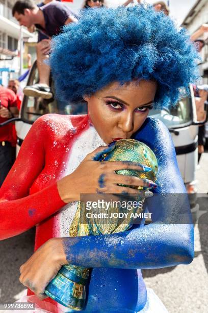 Woman poses with a replica of the World Cup, in the streets of Cayenne, in French Guiana, on July 15 after France won the Russia 2018 World Cup final...