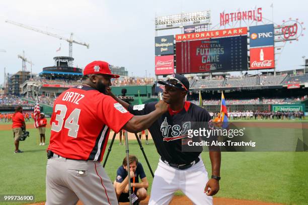 David Ortiz of the World Team joke around Torii Hunter of Team USA during player introductions prior to the SiriusXM All-Star Futures Game at...