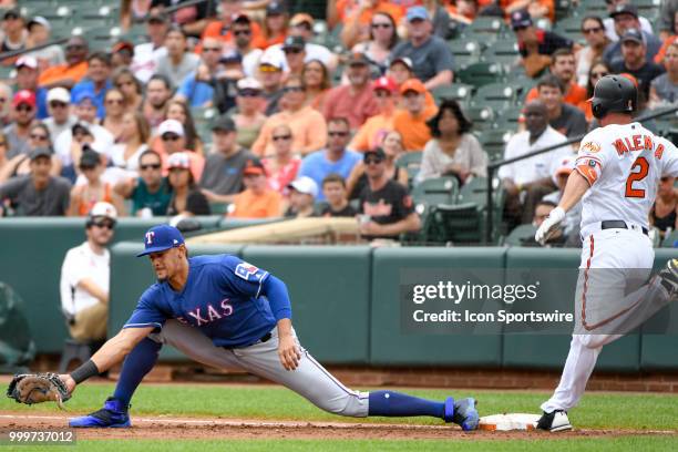 Texas Rangers first baseman Ronald Guzman stretches to retire Baltimore Orioles right fielder Danny Valencia in the second inning during the game...