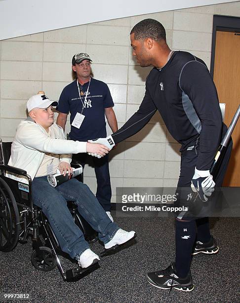 Jack Williams and Roger Williams shake hands with New York Yankees second baseman Robinson Cano at the starter event at NY Yankees batting practice...