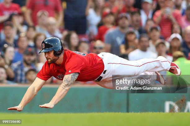Sam Travis of the Boston Red Sox slides safely past the tag of Russell Martin of the Toronto Blue Jays in the second inning of a game at Fenway Park...