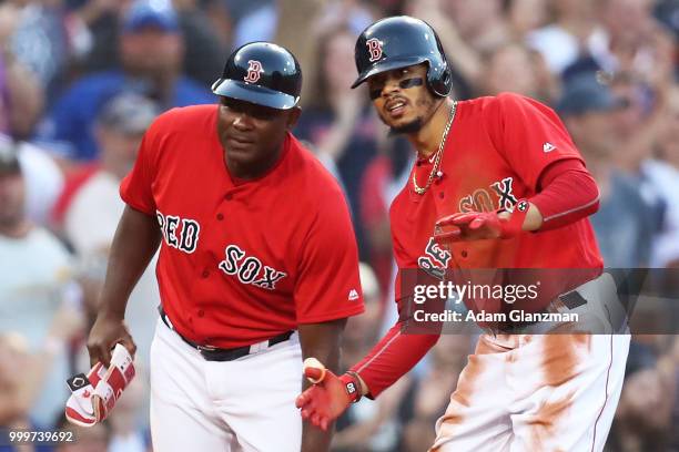 Mookie Betts of the Boston Red Sox reacts at third base after hitting his second triple of the game in the second inning of a game against the...