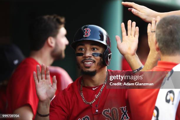 Mookie Betts of the Boston Red Sox returns to the dugout after scoring in the second inning of a game against the Toronto Blue Jays at Fenway Park on...