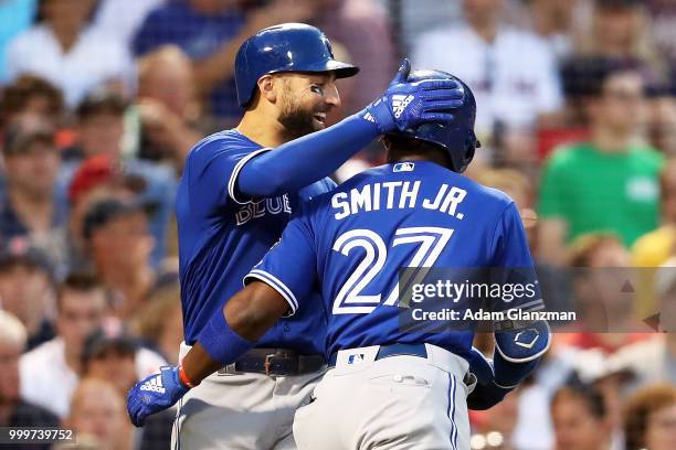 Dwight Smith Jr. #27 embraces Kevin Pillar of the Toronto Blue Jays after hitting a two-run home run in the third inning of a game against the Boston...