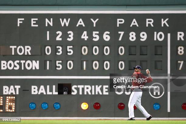 Martinez of the Boston Red Sox makes a throw from the outfield in front of the Green Monster in the eighth inning of a game against the Toronto Blue...