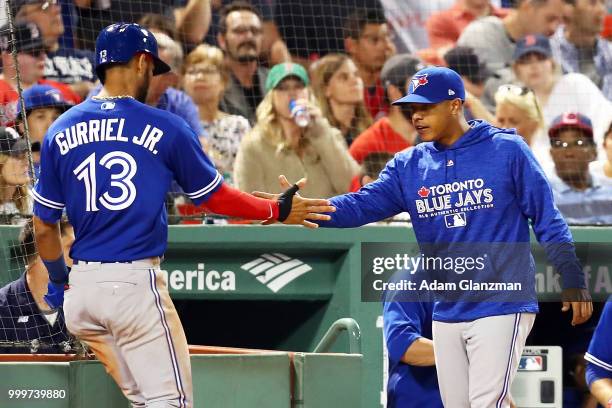 Lourdes Gurriel Jr. #13 of the Toronto Blue Jays returns to the dugout after scoring in the eighth inning of a game against the Boston Red Sox at...