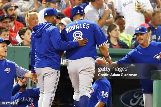 Kendrys Morales of the Toronto Blue Jays return to the dugout after scoring in the eighth inning of a game against the Boston Red Sox at Fenway Park...