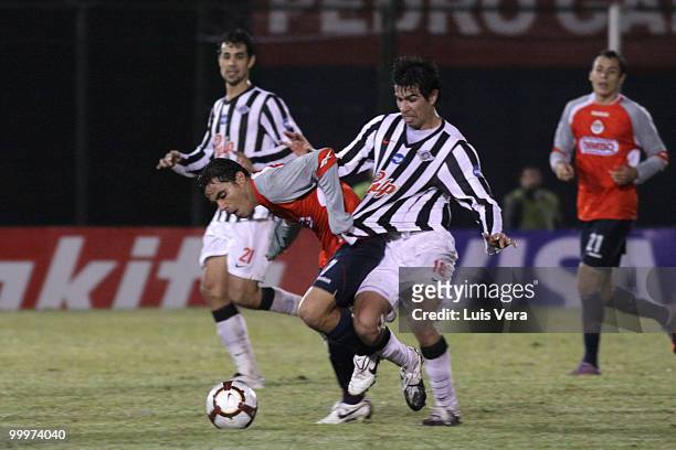 Omar Bravo of Chivas de Guadalajara fights for the ball with Victor Caceres of Libertad during a Libertadores Cup match at Defensores del Chaco...