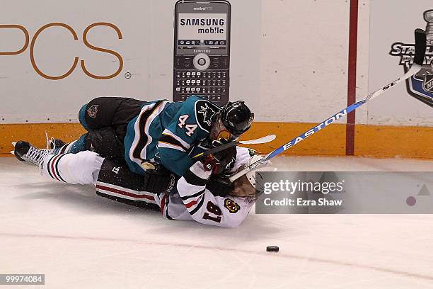 Marc-Edouard Vlasic of the San Jose Sharks battles for the puck on the ice as he lays on top of Marian Hossa of the Chicago Blackhawks in the second...