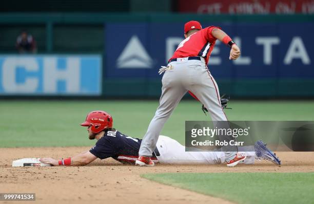 Brendan Rodgers of the Colorado Rockies and the U.S. Team beats the tag on Keibert Ruiz of the Los Angeles Dodgers and the World Team after stealing...