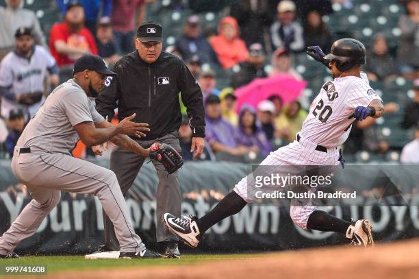 Ian Desmond of the Colorado Rockies beats the tag by Juan Nicasio of the Seattle Mariners for a triple in the seventh inning of a game at Coors Field...