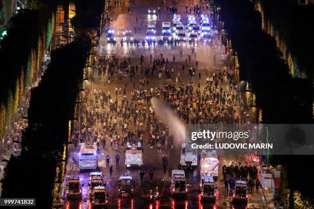 Police dispers people with water canons after celebrations following the Russia 2018 World Cup final football match between France and Croatia, on...