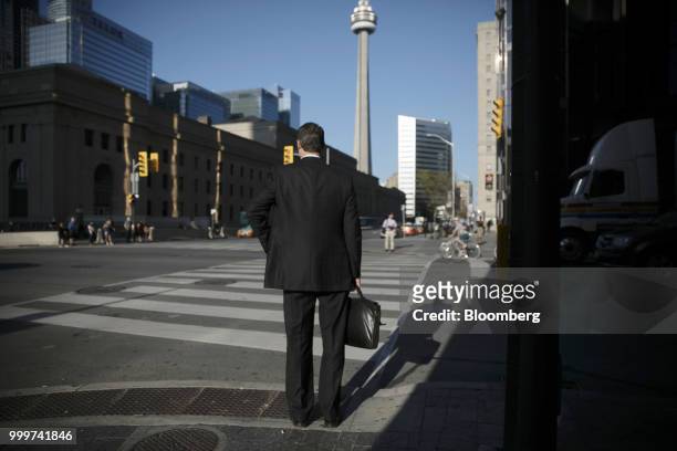 Pedestrian waits to cross a street in the financial district of Toronto, Ontario, Canada, on Wednesday, July 11, 2018. Canadian stocks were mixed...
