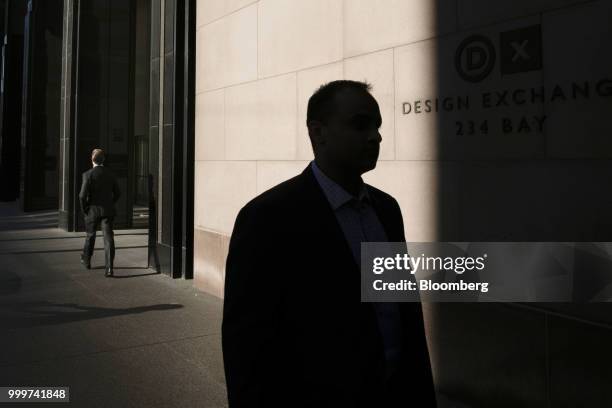 The silhouette of a pedestrian is seen walking in the financial district of Toronto, Ontario, Canada, on Wednesday, July 11, 2018. Canadian stocks...