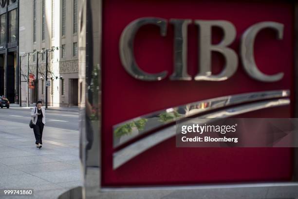 Pedestrian walks past a Canadian Imperial Bank of Commerce sign outside the company's headquarters in the financial district of Toronto, Ontario,...