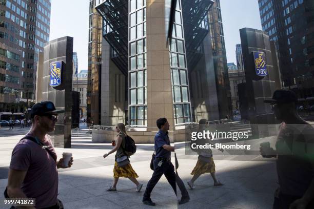 Pedestrians are reflected on a surface outside the Royal Bank of Canada head office in the financial district of Toronto, Ontario, Canada, on...