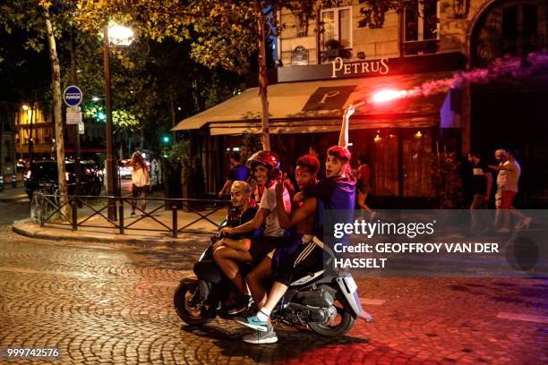 Four men on a scooter celebrate France's victory in the Russia 2018 World Cup final football match between France and Croatia, in Paris on July 15,...