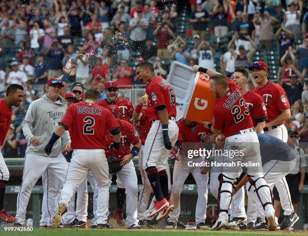 The Minnesota Twins celebrate as Brian Dozier of the Minnesota Twins crosses home plate after a walk-off grand slam against the Tampa Bay Rays during...