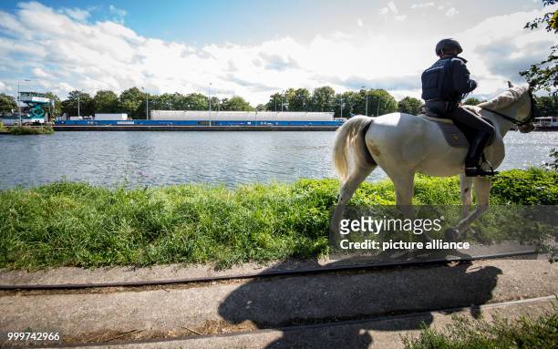 Policeman on horseback watches push boat Edda, used for another transport of castors with nuclear waste of energy company EnBW, arrive at the lock in...