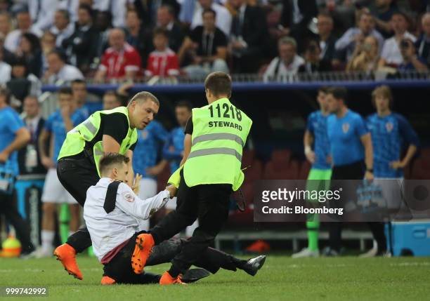 Security guards remove a protester from the pitch during the FIFA World Cup final match in Moscow, Russia, on Sunday, July 15, 2018. President...