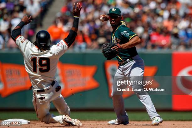 Marcus Semien of the Oakland Athletics completes a double play over Alen Hanson of the San Francisco Giants during the eighth inning at AT&T Park on...