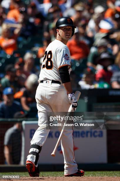 Buster Posey of the San Francisco Giants returns to the dugout after striking out against the Oakland Athletics during the ninth inning at AT&T Park...