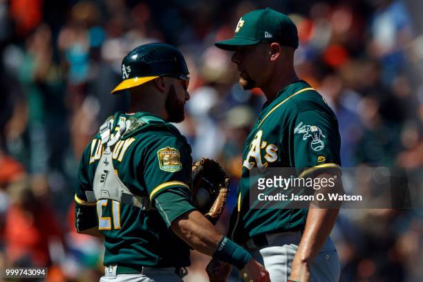 Blake Treinen of the Oakland Athletics celebrates with Jonathan Lucroy after the game against the San Francisco Giants at AT&T Park on July 15, 2018...