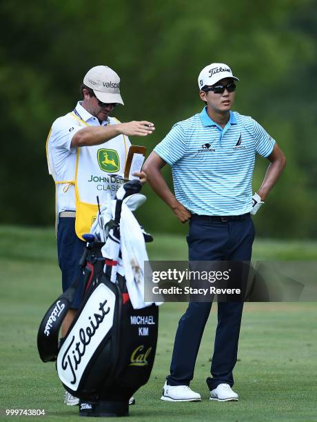 Michael Kim speaks with his caddie Andrew Gunderson on the 15th hole during the final round of the John Deere Classic at TPC Deere Run on July 15,...