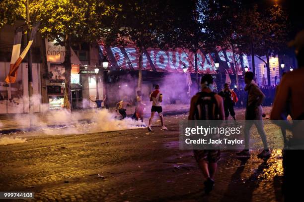 Tear gas is used by police as French football fans clash with police following celebrations on the Champs-Elysees after France's victory against...