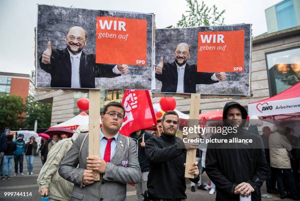 Protesters of the satirical party "The Party" hold up poster of SPD candidate for Chancellor with thumbs up that read "WE give up" at an SPD election...