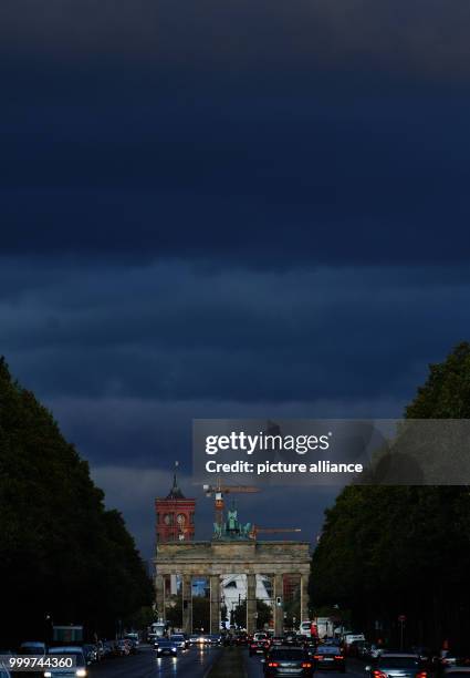 Dark clouds can be seen above the Brandenburg Gate in Berlin, Germany, 06 September 2017. Photo: Paul Zinken/dpa