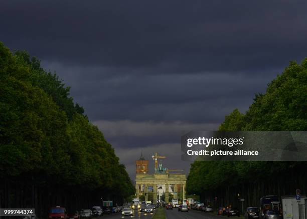 Dark clouds can be seen above the Brandenburg Gate in Berlin, Germany, 06 September 2017. Photo: Paul Zinken/dpa