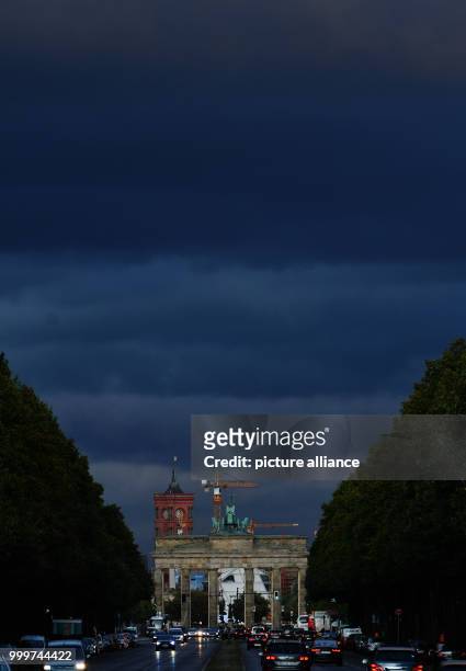 Dark clouds can be seen above the Brandenburg Gate in Berlin, Germany, 06 September 2017. Photo: Paul Zinken/dpa