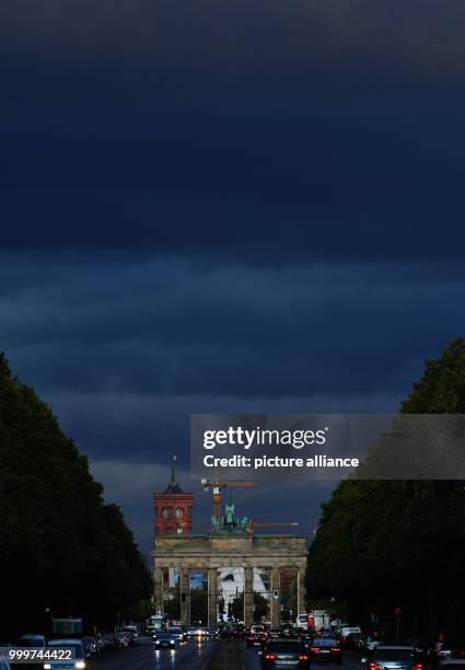 Dark clouds can be seen above the Brandenburg Gate in Berlin, Germany, 06 September 2017. Photo: Paul Zinken/dpa