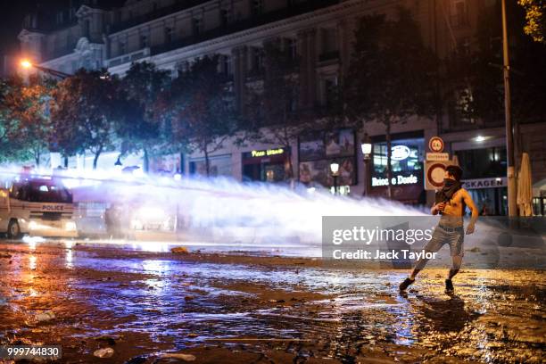 Water cannon is used as French football fans clash with police following celebrations on the Champs-Elysees after France's victory against Croatia in...