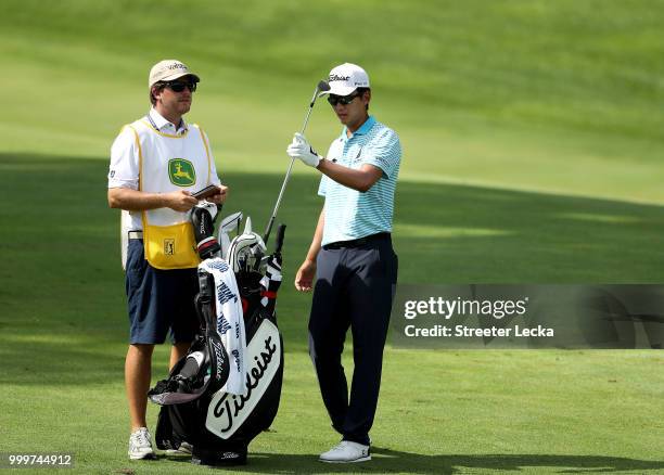 Michael Kim and his caddie Andrew Gunderson wait to hit on the 14th hole during the final round of the John Deere Classic at TPC Deere Run on July...