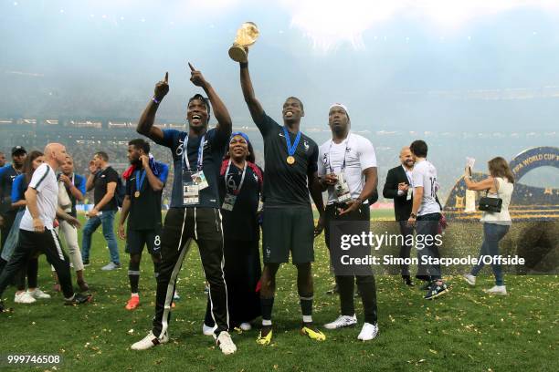 Paul Pogba of France hold the trophy aloft alongside his mother, Yeo, and his brother Mathias and Florentin after the 2018 FIFA World Cup Russia...