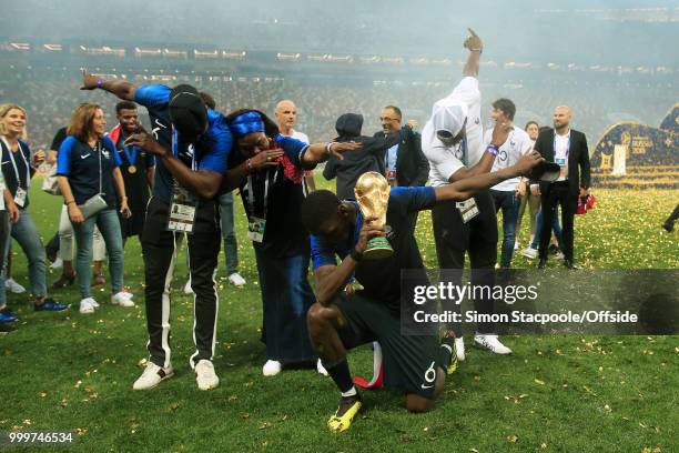 Paul Pogba of France celebrates with his mother, Yeo, and brothers Mathias and Florentin as they perform a dab with the trophy after the 2018 FIFA...